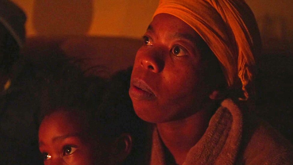 Ruby Bambatha pictured with her child by candlelight in Khayelitsha, South Africa