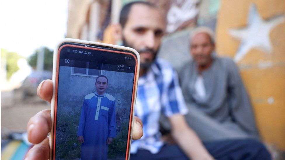 Мужчина показывает фотографию своего брата Али, который погиб вместе со своими тремя двоюродными братьями в Ливии после того, как на страну обрушился шторм «Дэниел»