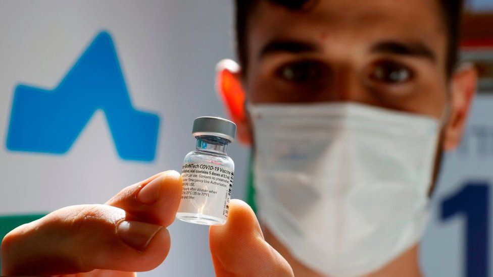 healthcare worker holding vaccine