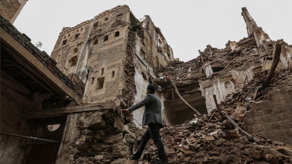 A man walks in the ruins of a damaged building in Sanaa
