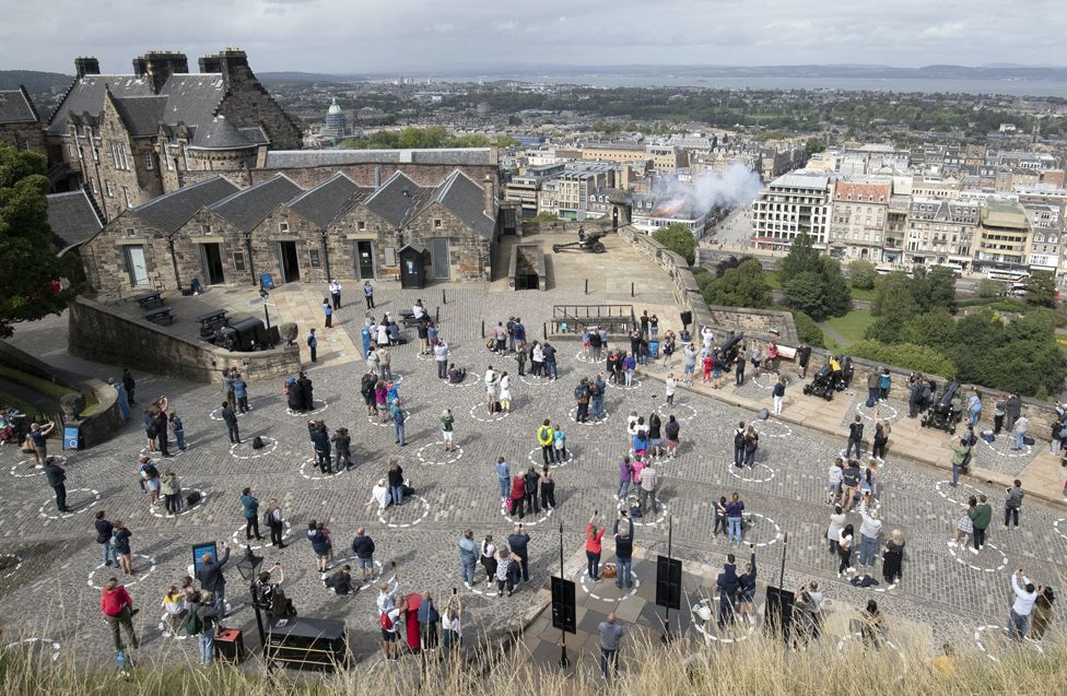 Visitors at Edinburgh Castle standing socially distanced in marked out circles