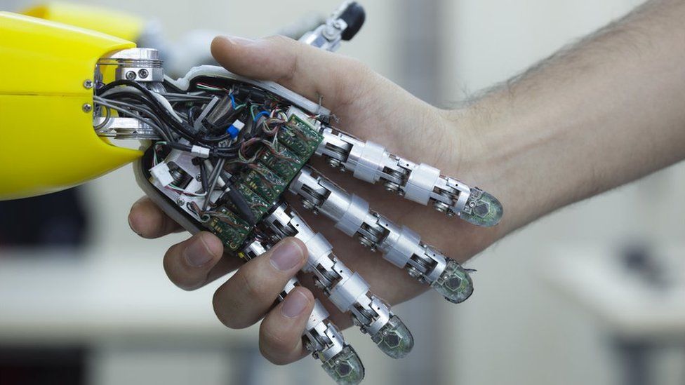 Robotic hand shakes human hand