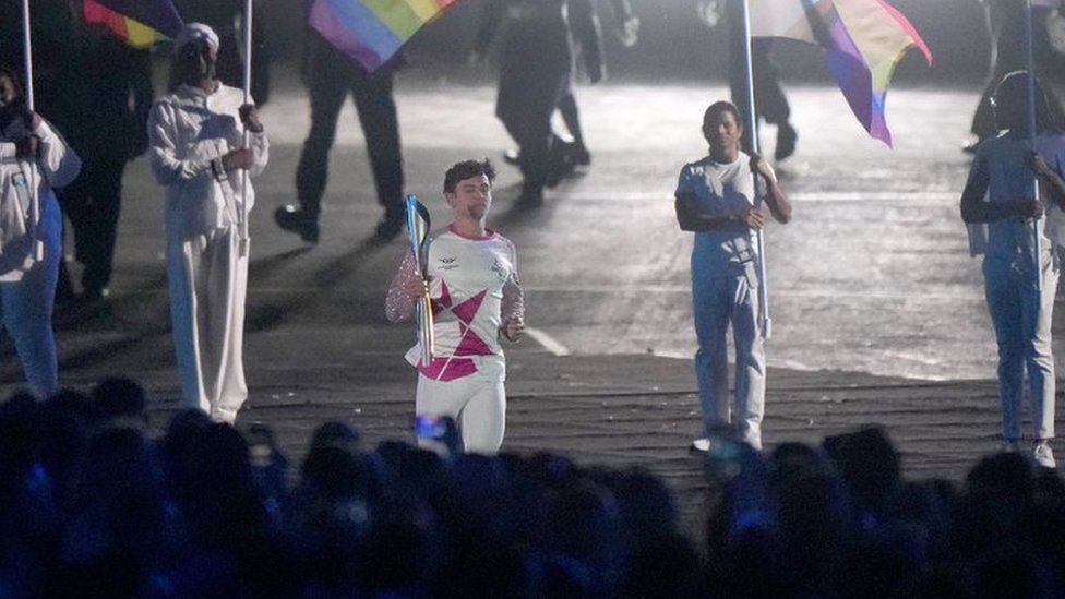 Tom Daley carrying the torch at the Birmingham 2022 Commonwealth Games