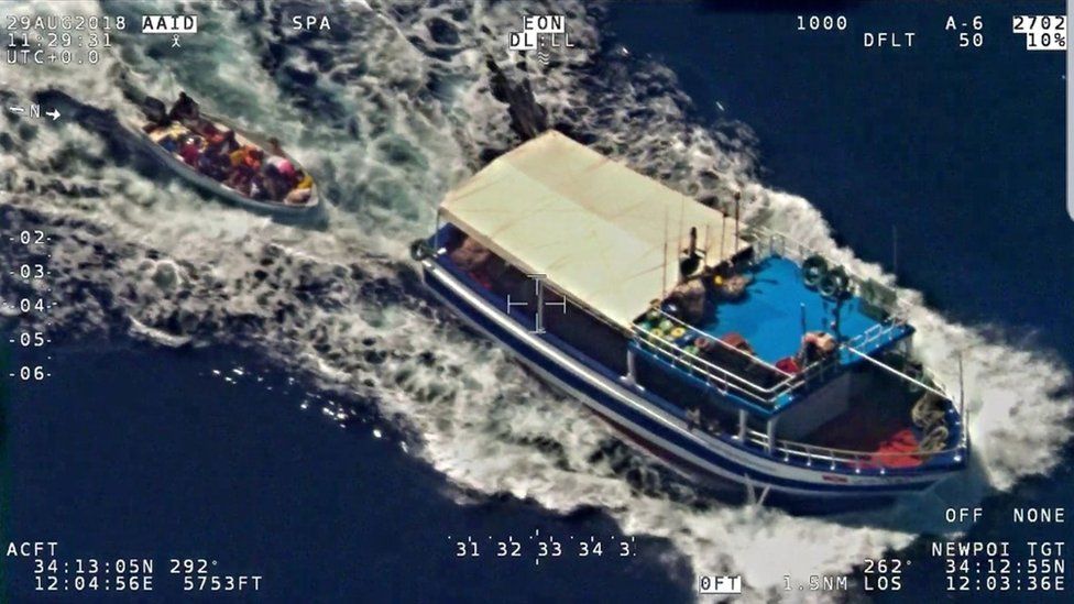 A photo released by Italian authorities of the fishermen towing the migrants' boat