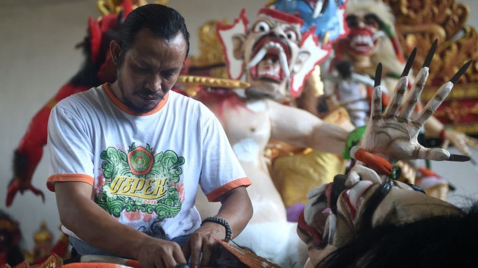 A man prepares effigies symbolising evil, known as "ogoh-ogoh", for a parade before the Day of Silence