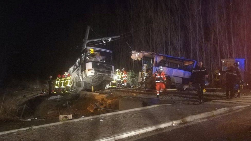 Rescue workers are seen on the site of collision between train and school bus in Millas, France December 14, 2017