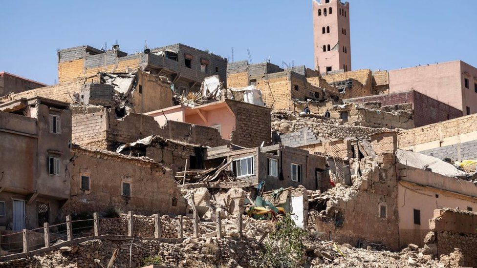 The minaret of a mosque stands behind damaged or destroyed houses following an earthquake in Moulay Brahim, Al Haouz province