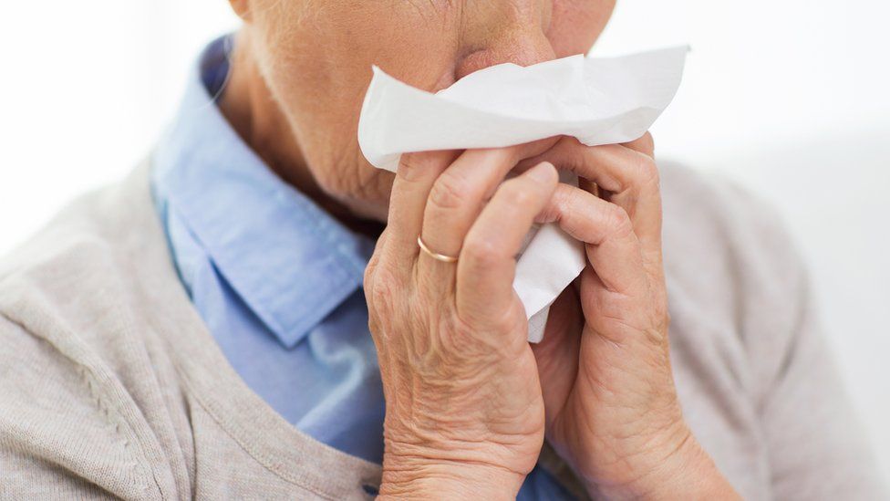 A generic image of a woman blowing into a tissue