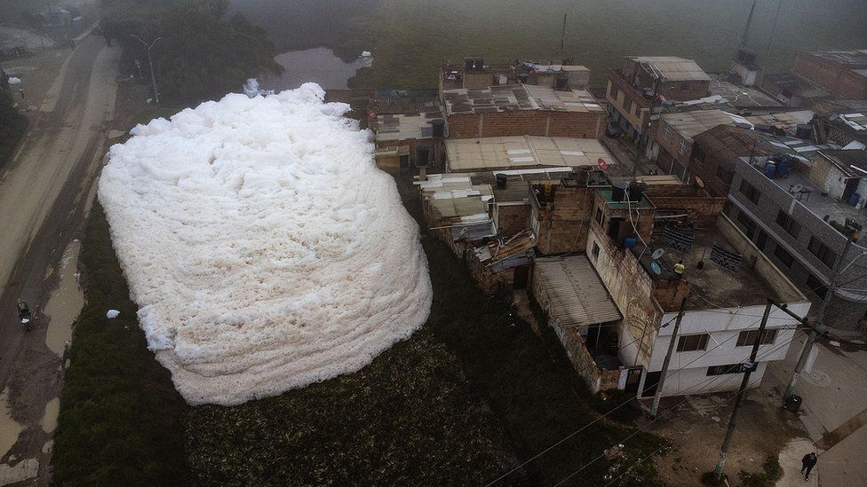 Aerial view shows pungent foam which formed in a polluted river and invaded the Los Puentes neighbourhood, in Mosquera, west of Bogota, on April 26, 2022