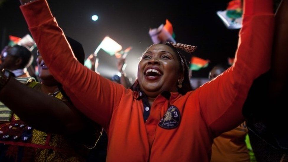 A supporter of presidential election candidate of Burkina Faso Roch Marc Christian Kabore celebrate after preliminary results showed him to be the winner of recent elections, supporters gather outside Kabore’s campaign headquarters in Ouagadougou, Burkina Faso, Tuesday, Dec. 1, 2015