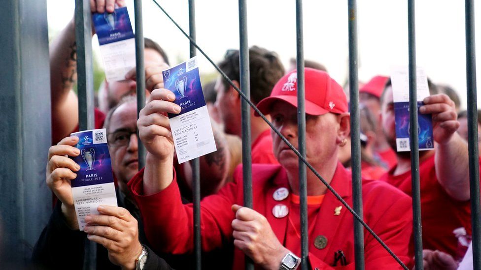 Liverpool fans stuck outside the ground show their match tickets during the Uefa Champions League Final at the Stade de France, Paris