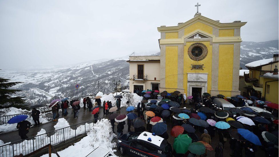 People gather at the church of San Nicola Vescovo on 24 January 2017 in Farindola for the funeral of Alessandro Giancaterino, one of the victims of the avalanche that hit the hotel Rigopiano after an earthquake on 18 January 2017 in central Italy