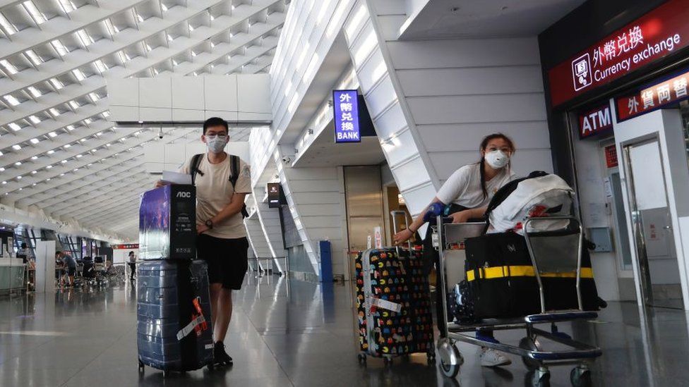 Прибывающие иностранные студенты ждут такси, которое доедет до карантинных отелей в международном аэропорту Таоюань на фоне пандемии COVID-19, Таоюань, Тайвань, 26 сентября 2021 г.