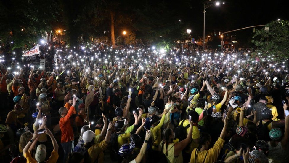 As part of a peaceful demonstration in the city on Monday evening, thousands of protesters walked through the streets holding aloft lit mobile phones