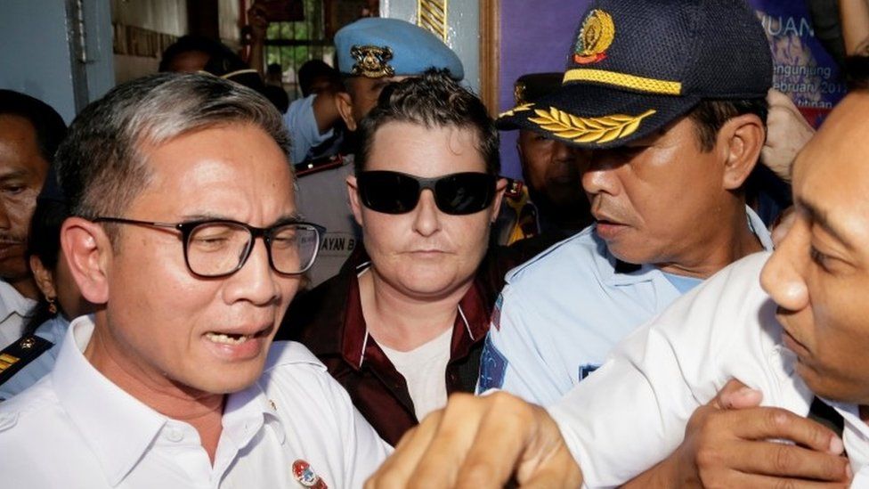 Australian Renae Lawrence (C) surrounded by police leave prison in Bali