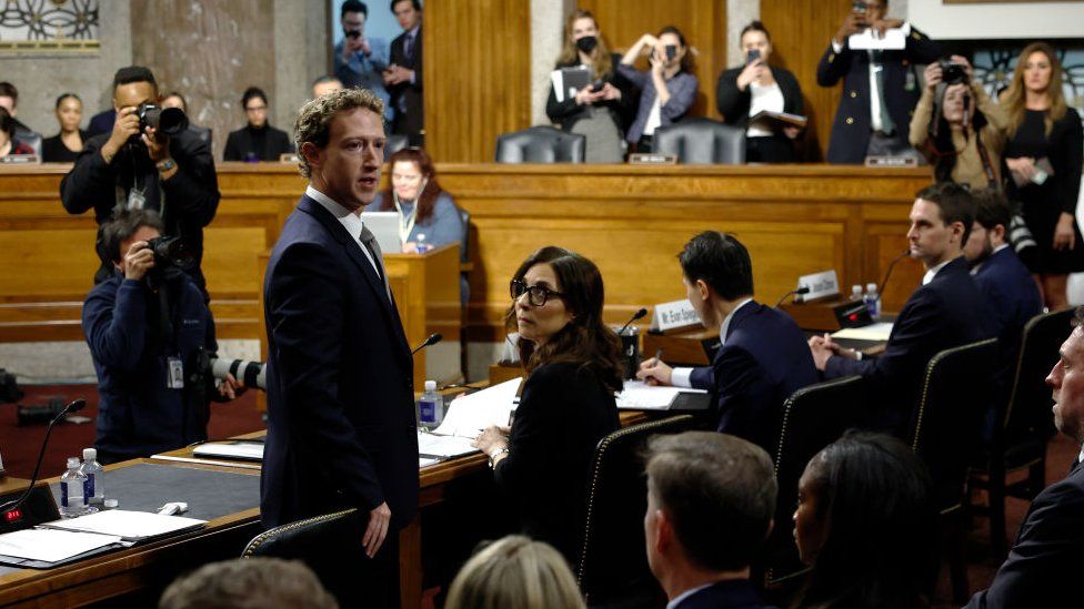 Mark Zuckerberg standing to speak to the audience