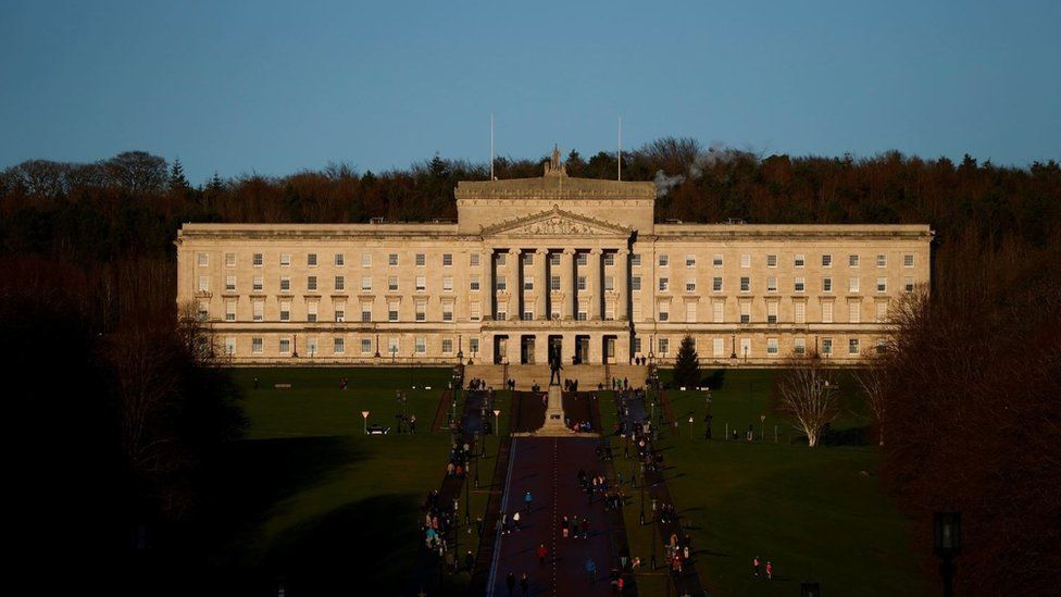 People walk through the grounds of the Stormont Parliament buildings in Belfast, Northern Ireland, on 30 December 2020.