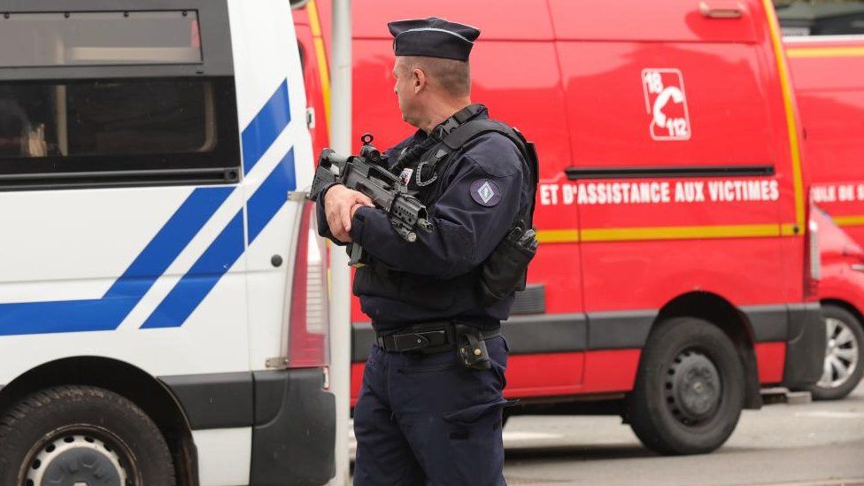 A police officer guards the high school in Arras, northeastern France, 13 October 2023