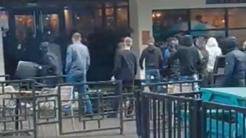 Football fans outside Fat Cat throwing chairs