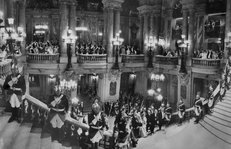 Queen Elizabeth II, ascending the Grand Staircase at the Opera in Paris during a state visit to the French capital, 8 April 1957. The image is a montage of 15 separate pictures.