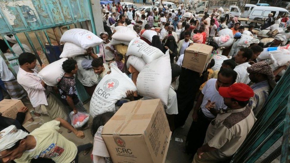 People carry food aid delivered by the International Committee of the Red Cross to internally displaced people in the Red Sea port city of Hudaydah, Yemen (21 July 2018)