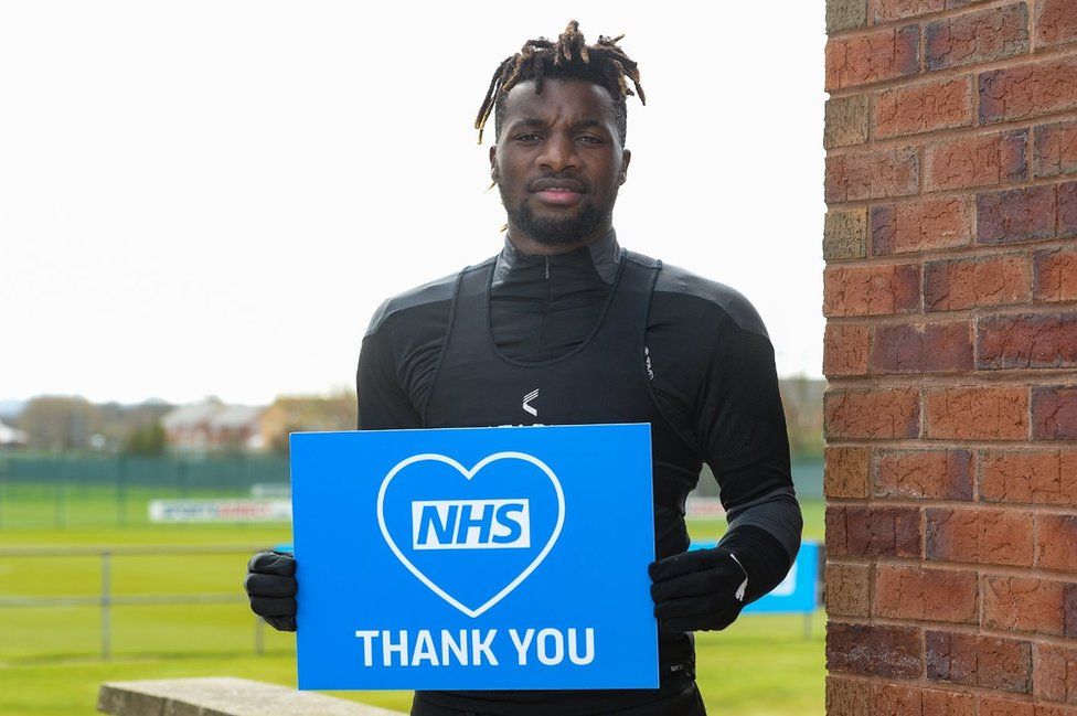 Allan Saint-Maximin Holds thank you NHS sign