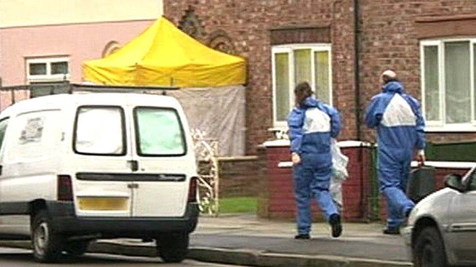 Forensic officers approach the house in Norris Green