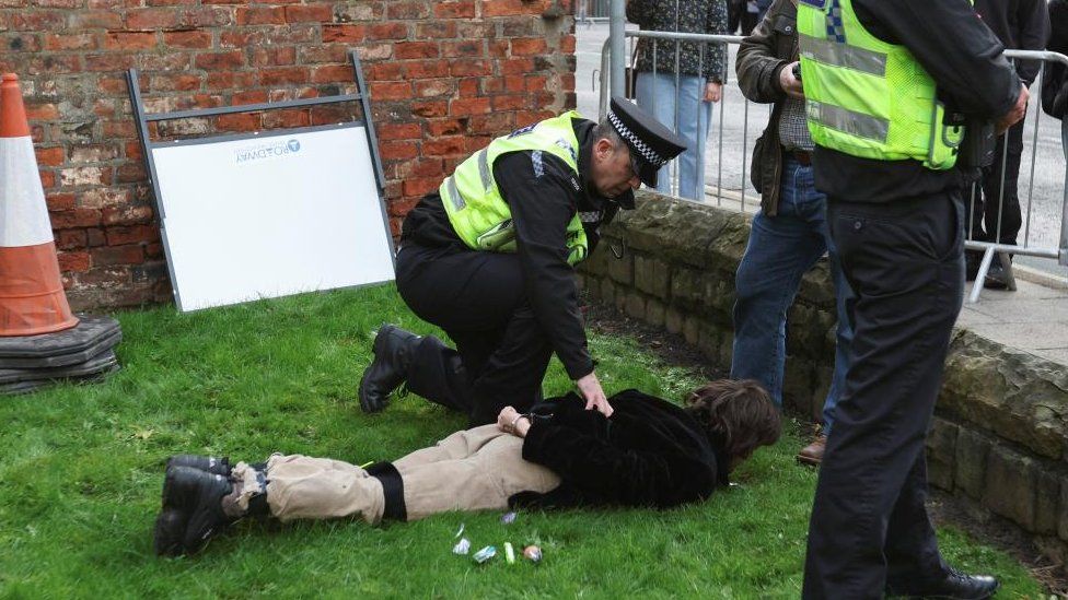 Man being restrained by police