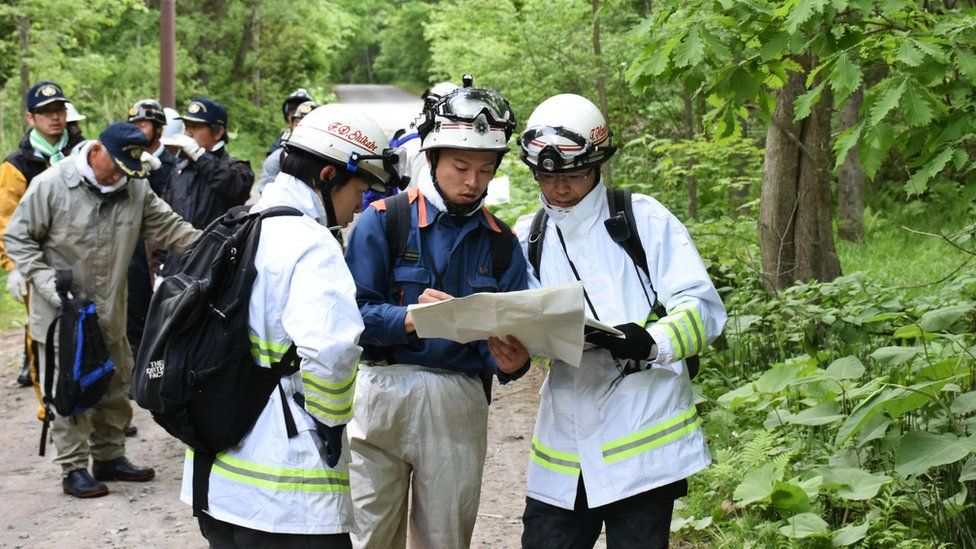 Twelve men, part of a search team looking for the missing boy, in woods, on 30 May 2016.
