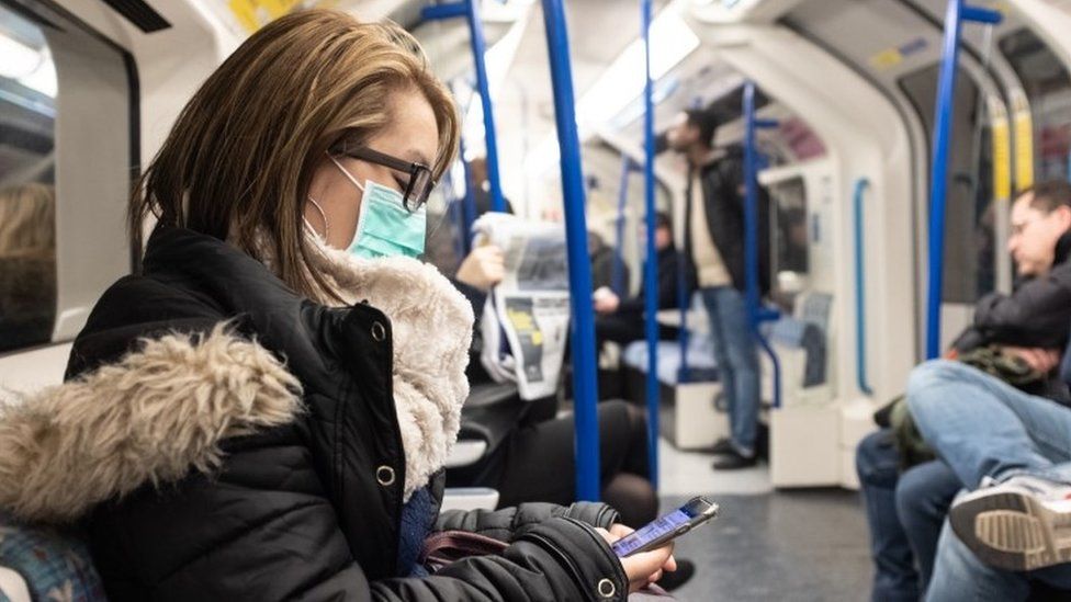 Woman wearing face mask on Tube