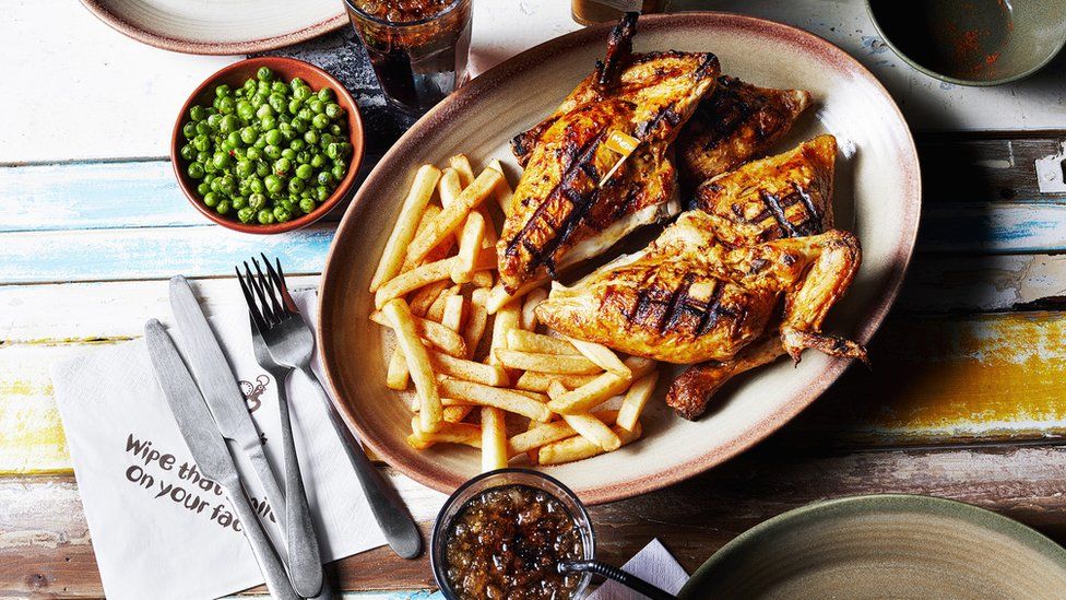 Nandos meal, chicken, chips, peas and a coke.