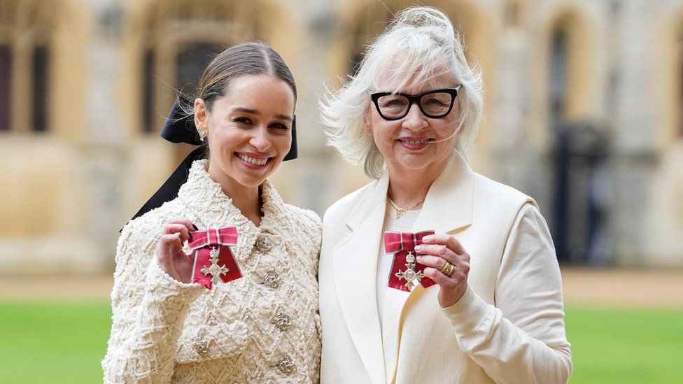 Emilia and Jenny Clarke hold their MBEs outside Windsor Castle