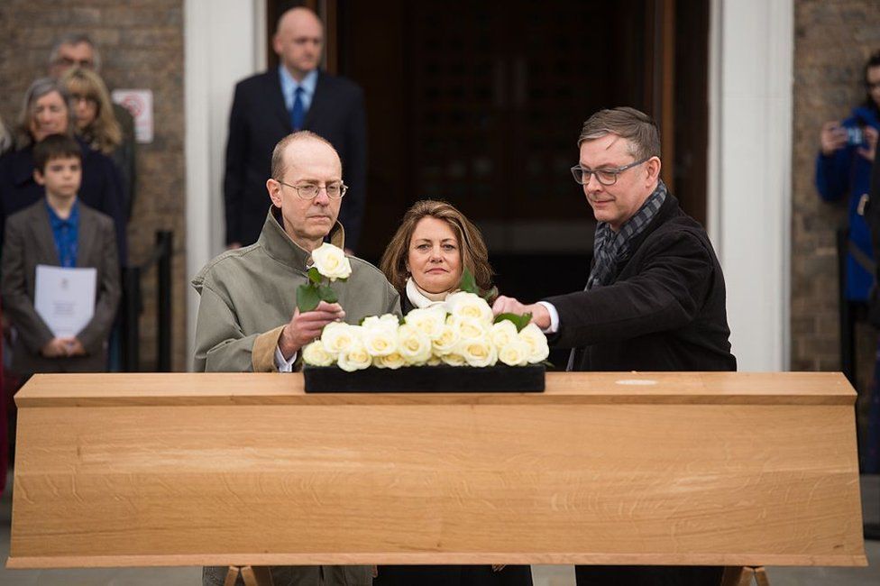 Michael Ibsen and two other descendants place roses on the oak coffin with the remains of the monarch during a service held outside the University of Leicester in Leicester, Leicestershire, England on March 22, 2015, prior to a ceremonial procession towards the new site of the king's reinterment some 530 years on from his violent death in 1485 at the Battle of Bosworth.