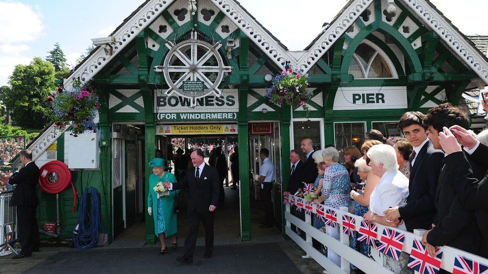 Queen Elizabeth II accompanied by Bill Bewley, Chairman of Windermere Lake Cruises arrives at Bowness on Windermere Pier, Cumbria, North West England on 17 July 2013