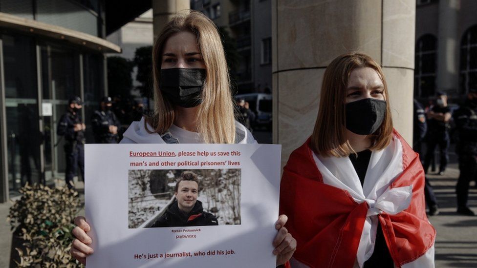 A woman holds a sign asking the EU to help "save" Protasevich's life