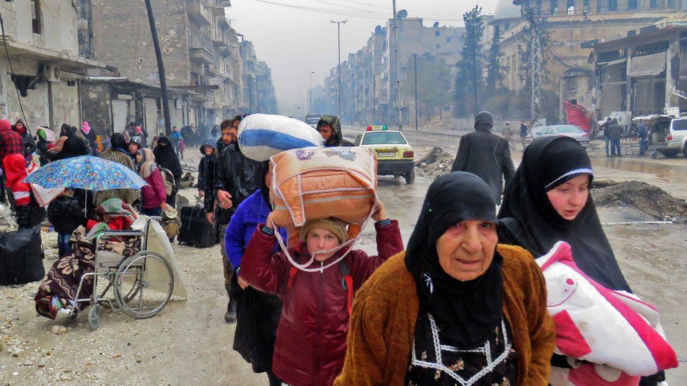 Syrian civilians flee the Bustan al-Qasr district of Aleppo during fighting on 13 December 2016