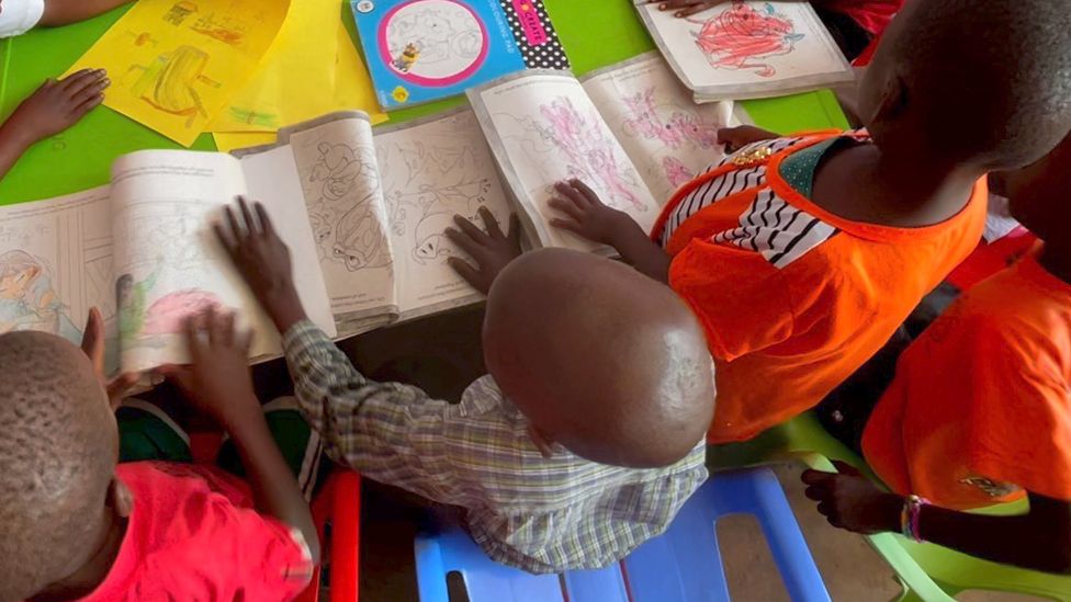 Children with colouring books at a BCF home in Kampala, Uganda