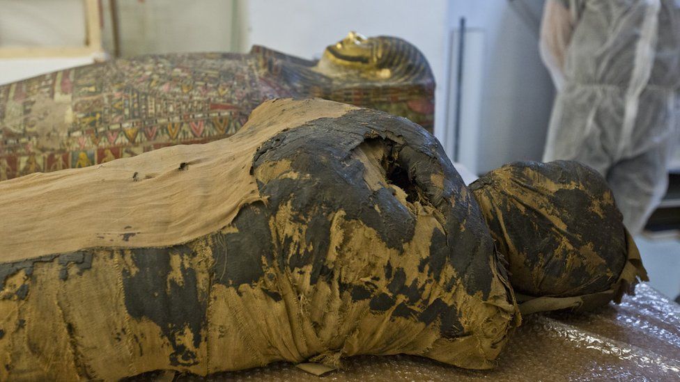 The mummy is seen lying down in place by casing