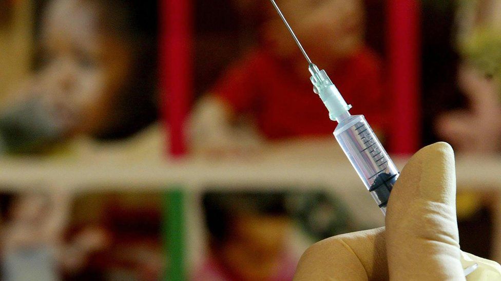 A nurse handles a syringe at a medical centre
