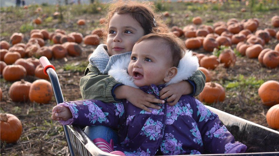 Children in pumpkin wheelbarrow