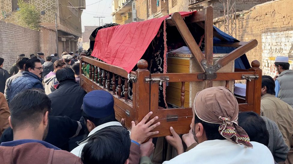 Men carrying coffin at the funeral of Irfan Ullah, a police inspector killed in yesterday’s explosion.