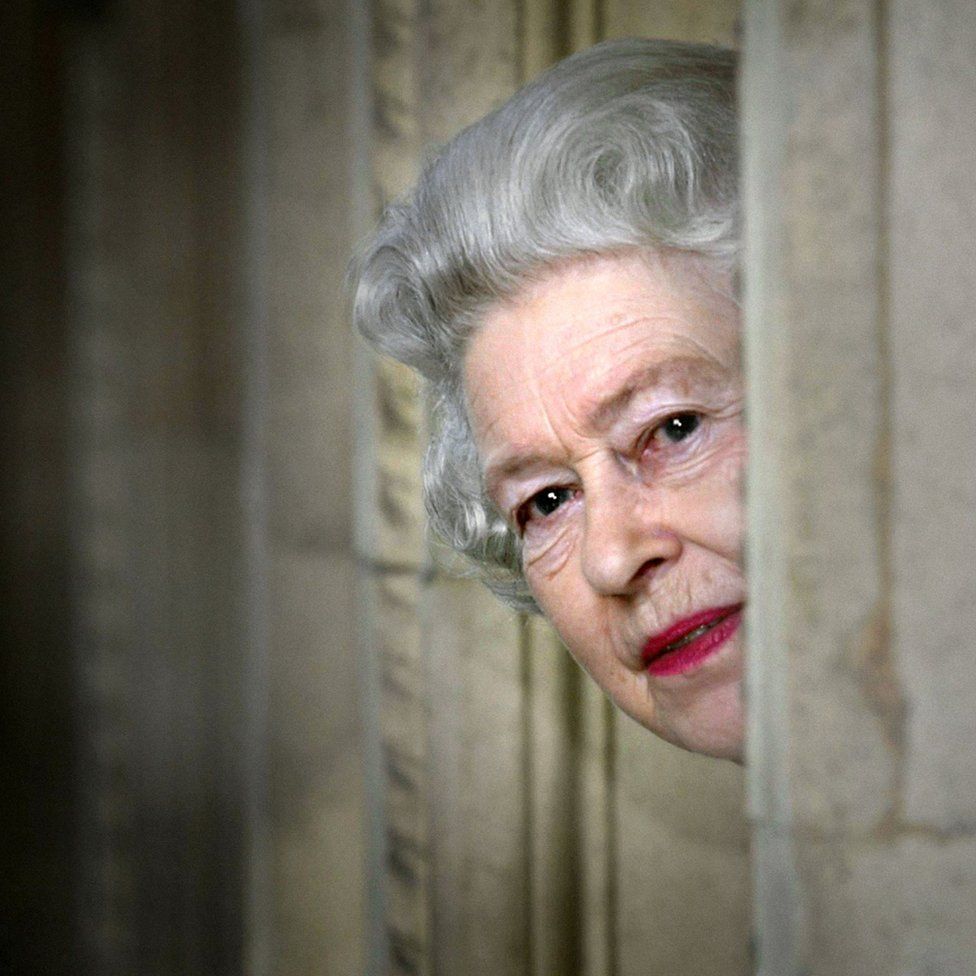 Britain's Queen Elizabeth II peers round a corner during a visit to the Royal Albert Hall in London, marking the end of an eight year restoration program