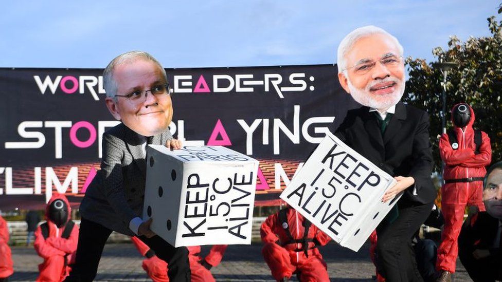 Climate change activists wearing masks depicting images of World leaders, including Australia's Prime Minister Scott Morrison and India's Prime Minister Narendra Modi, take part in a "Squid Game" themed demonstration near the Scottish Event Campus (SEC), the venue of the COP26 UN Climate Change Conference in Glasgow, Scotland on November 2, 2021. -