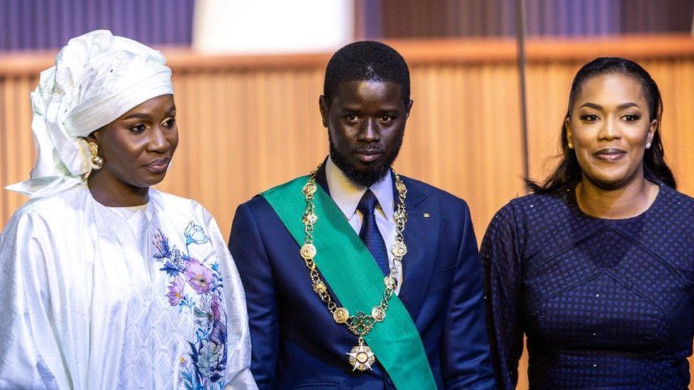 Bassirou Diomaye Faye (C) and his wives pose after his swearing-in.