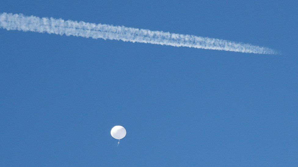 A jet flies by a suspected Chinese spy balloon as it floats off the coast in Surfside Beach, South Carolina,