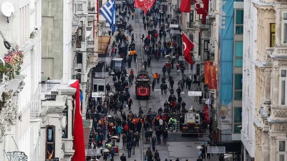 People walk on Istiklal Street near the site of Saturday's bomb explosion in Istanbul (20 March 2016)