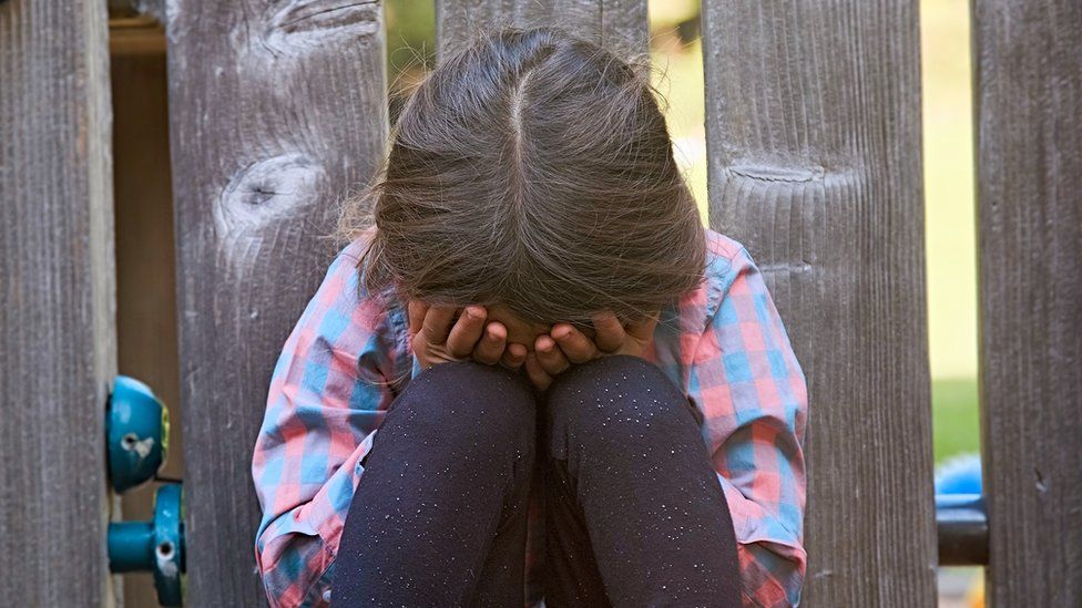 Stock image of child with their head in their hands