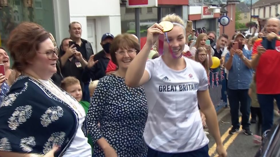 Lauren Price holding up her gold medal