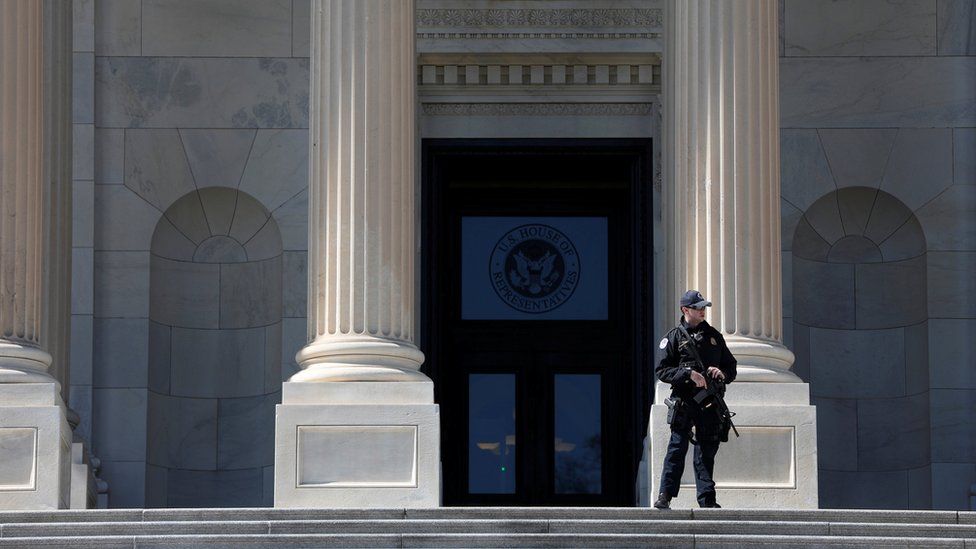 A member of the Capitol Police armed with a rifle stands guard outside the Capitol Building in Washington