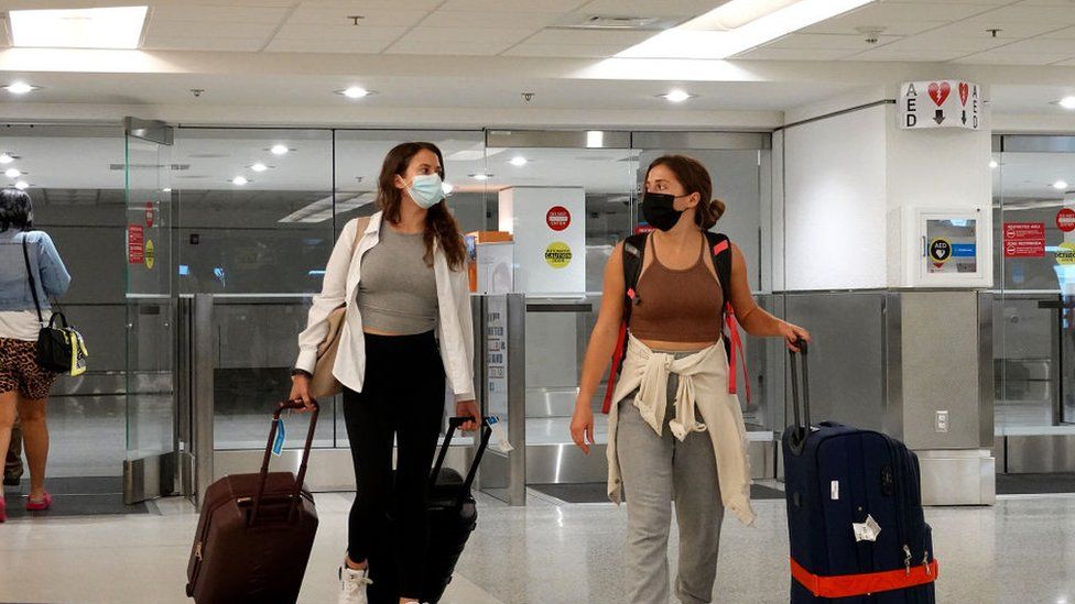 Travelers exit from the International arrivals door at Miami International Airport.